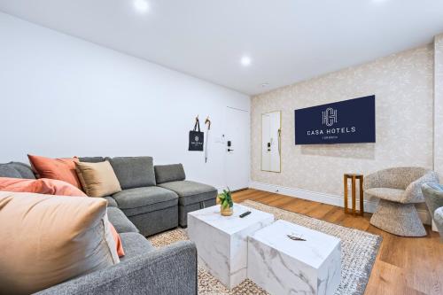 a living room with a couch and a table at Casa Hotels Gerrard Modern Downtown Suite in Toronto