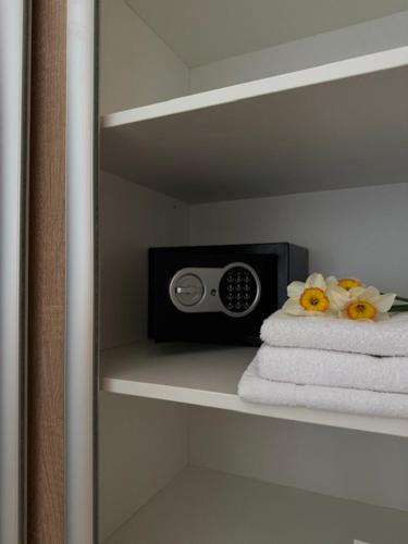 a bathroom shelf with a radio on top of towels at Penzión Aurora Patince in Patince