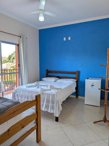 a bedroom with two beds and a blue wall at Aura de Cunha in Cunha