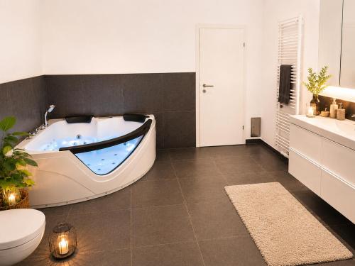 a bathroom with a tub with a toilet and a sink at Villa Schönfeld in Schönfeld