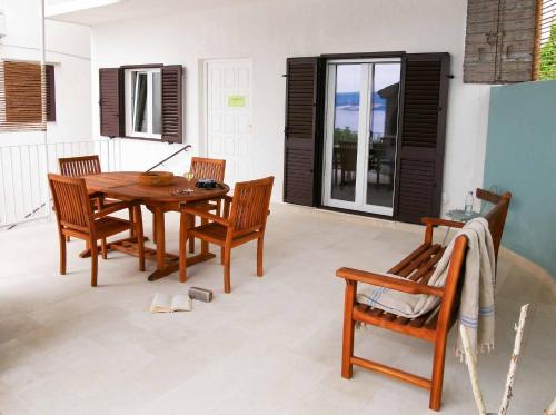 a dining room with a wooden table and chairs at holiday by the sea in Marusici 