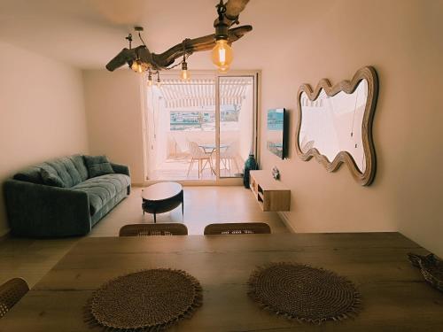 a living room with a table and a couch at Les pieds dans l'eau in Mèze