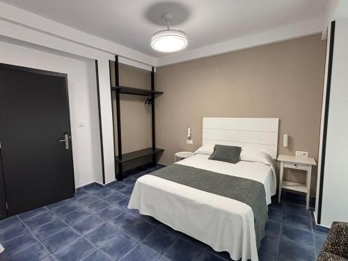a bedroom with a large bed and a black door at HOSTAL CASA JULIO - Auto Check-in in Culleredo
