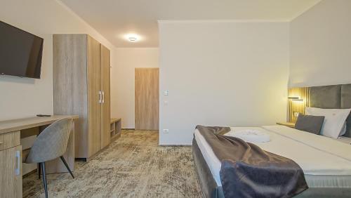 a hotel room with a bed and a tv at Sub Cetate in Râşnov
