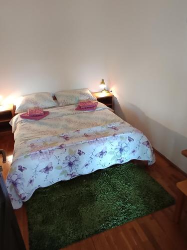 a bedroom with a bed and a green rug at Guesthouse Pavličić in Drežnik Grad