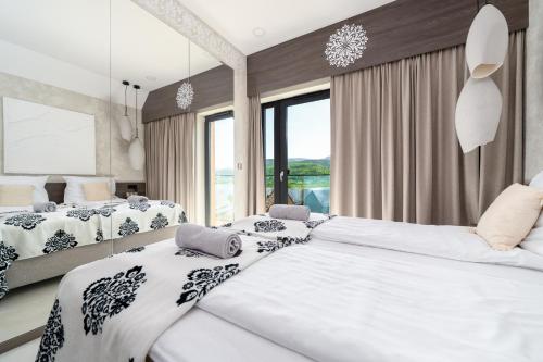 a bedroom with two beds and a large window at Lake Chwil 5618 widok na zalew i góry in Sosnówka