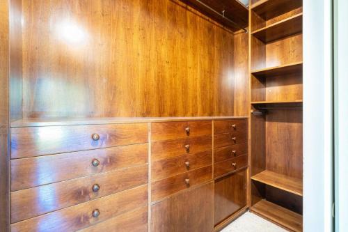 a closet with wooden walls and wooden drawers at Villa San Siro Olympic Stadium in Milan