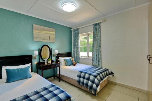 a bedroom with two beds and a window at Caribbean Estates by MyResorts in Port Edward