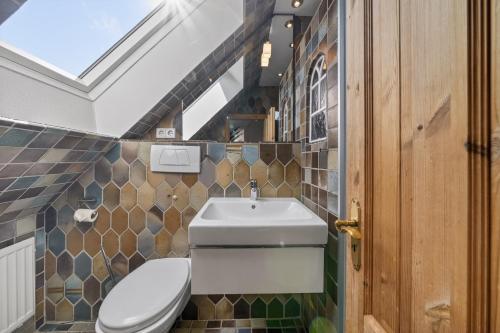 a bathroom with a toilet and a sink at Liiger-Hoern-DG-Wohnung-4-Moewe in Tinnum