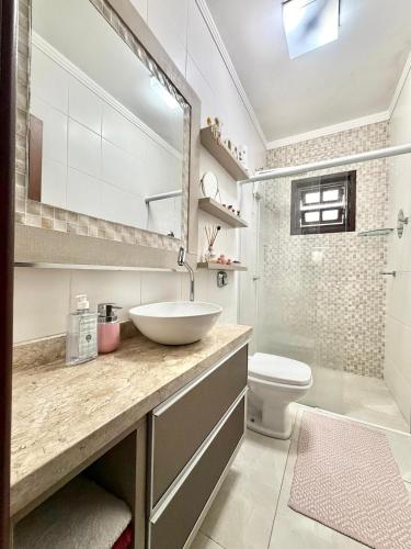 a bathroom with a sink and a toilet at Quarto 4V Joinville Costa e Silva perto Centro in Joinville