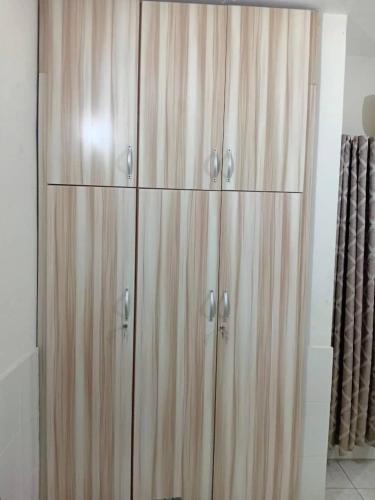 a wooden cabinet with four doors in a room at Vesper Apt-Osu in Christiansborg