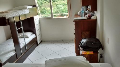 a dorm room with bunk beds and a backpack at Apartamento Hotel Cavalinho Branco in Águas de Lindoia