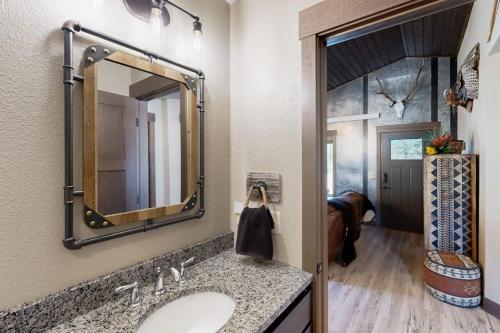a bathroom with a sink and a mirror at Rost Place Round-Up in Sturgis