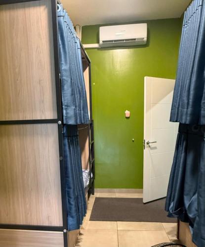 a room with a green wall and a door with curtains at Hostel BM19 in Madrid