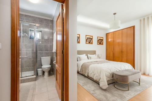 a bedroom with a bed and a bathroom with a shower at Cinfães Centro Stay in Cinfães