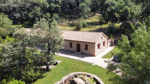 an aerial view of a stone house in a forest at Apartamentos El Escondite de Pedro Malillo in Candeleda