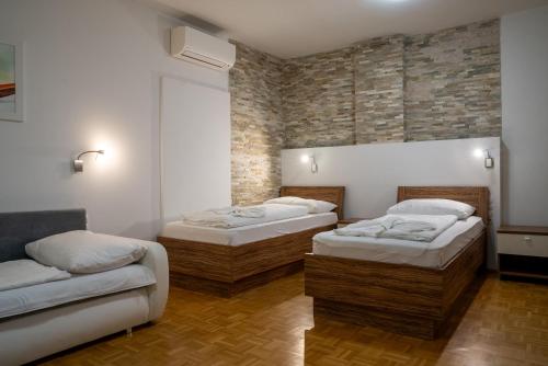 a room with two beds and a couch at Hotel - Restaurant Valley Rose in Vienna