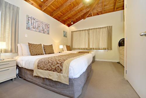 um quarto com uma cama grande e uma janela em Takapuna Motor Lodge em Auckland