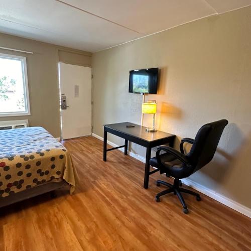 a bedroom with a desk and a bed and a chair at Americas Best Value Inn in Danville