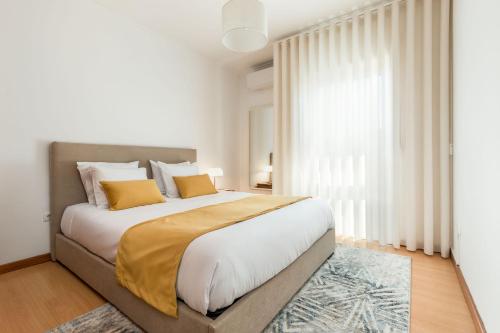 a bedroom with a large bed with yellow pillows at Cinfães Centro Stay in Cinfães