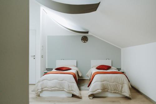 two beds in a room with white walls at Aura Residence in San Biagio
