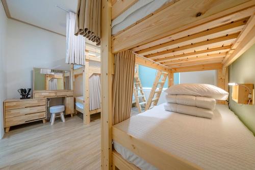 a bedroom with a bunk bed and a desk at Visitor guesthouse in Jeju