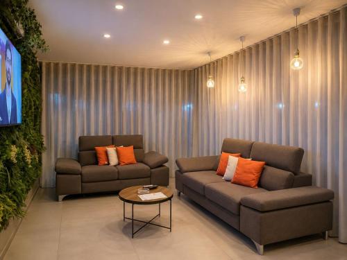 a living room with two couches and a table at Hotel Futuro in Aversa
