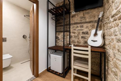 a room with a desk with a guitar on the wall at Kitarat Berat Castle in Berat