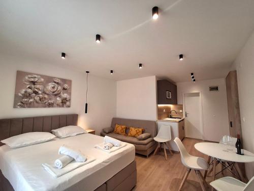 a bedroom with a bed and a couch and a table at Villa Rossa 2 in Tučepi