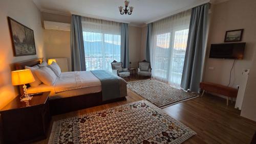 a bedroom with a bed and a large window at Ephesus Suites in Selçuk