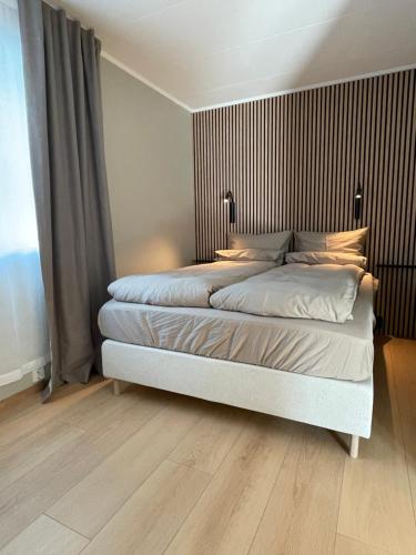 a bedroom with a large bed with a wooden floor at City Svolvær Apartment in Svolvær