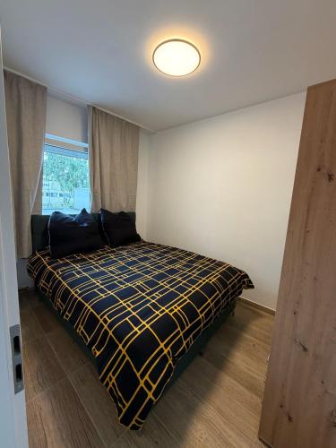 a bedroom with a bed with a yellow and black blanket at Downtown in Bonn