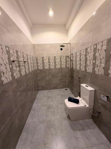 a bathroom with a toilet and a shower and a sink at Cozy Bay Hotel in Arugam Bay