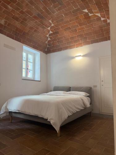 ein Schlafzimmer mit einem Bett mit einer Ziegeldecke in der Unterkunft Le volte in Seravezza