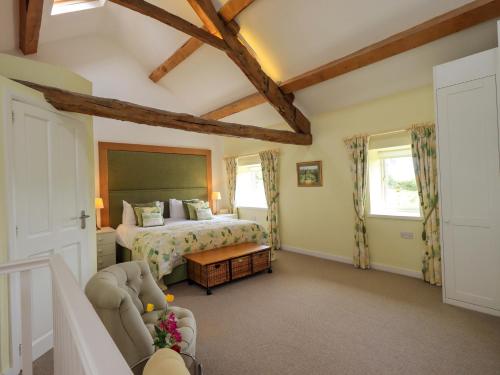 a large bedroom with a bed and a couch at Kestrel Cottage in Grange Over Sands