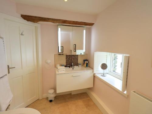 a bathroom with a sink and a mirror at Kestrel Cottage in Grange Over Sands