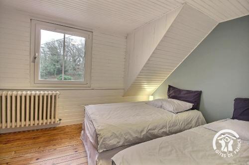 a bedroom with two beds and a window at Ty amzer'zo in Ploulech