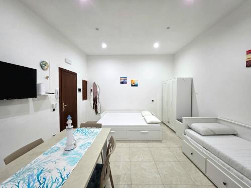 a white room with a bed and a table in it at Il Silenzio del Mare in Gaeta