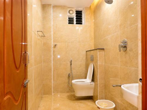 a bathroom with a toilet and a sink and a shower at Raja's Paradise Inn in Chennai