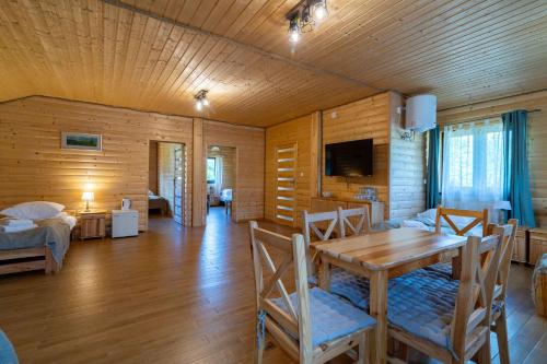 a dining room with a table and a bedroom at Star-Dadaj Lake Camp in Barczewo