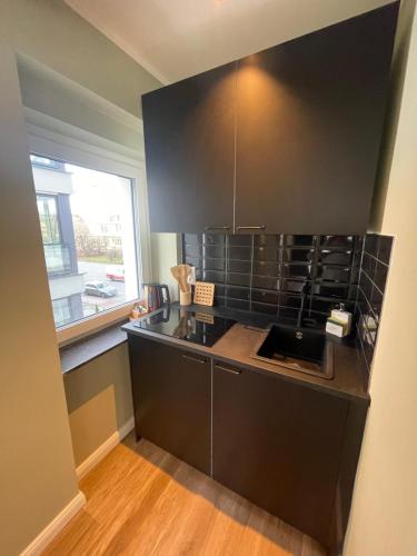 a kitchen with a black counter top and a window at Milano Apartment in Hamburg