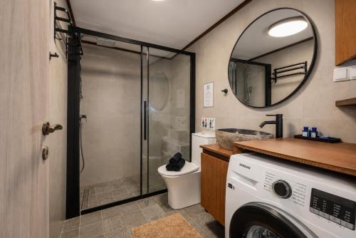 a bathroom with a shower and a toilet and a mirror at Seaside Breeze Villa - Beachfront, Private Pool, BBQ in Agia Pelagia