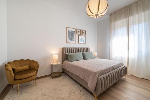 a bedroom with a bed and a chair at Casa MaMi in Gatteo a Mare