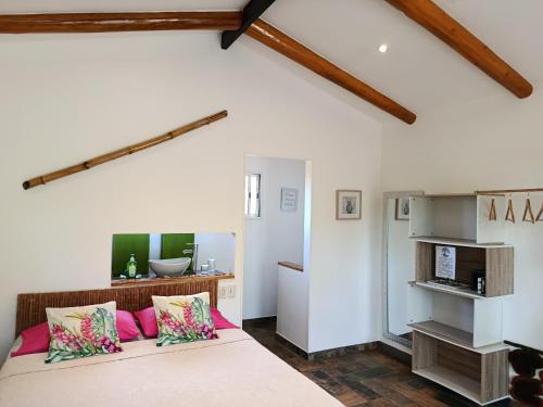 a bedroom with a large bed with pink pillows at Baliyana Lodge in San José Pinilla