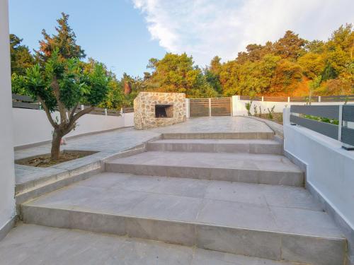 a set of concrete steps with a tree on top at Aroma Zia Residences 2 in Lagoúdi Zía