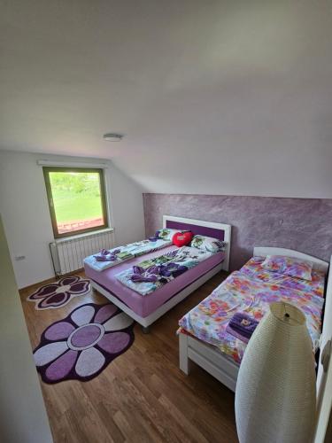 a bedroom with two beds and a window at Apartmani NINA Zlatar in Nova Varoš