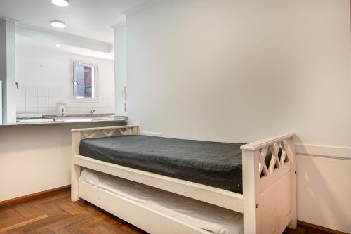 a bedroom with a bunk bed in a white room at Lofty Departamentos Temporarios in Córdoba