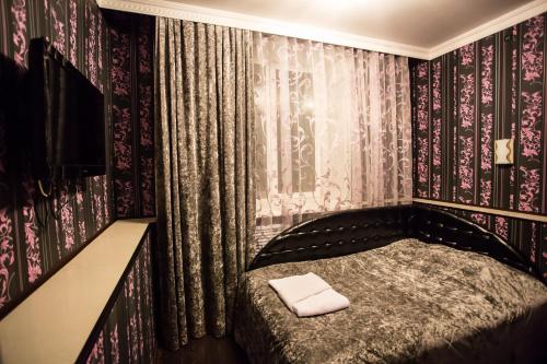 ヤクーツクにあるAlmaz Hotelの壁紙のベッドルーム1室(ベッド1台付)