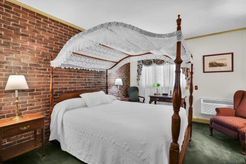 a bedroom with a canopy bed and a brick wall at Lamies Inn & The Old Salt Tavern in Hampton