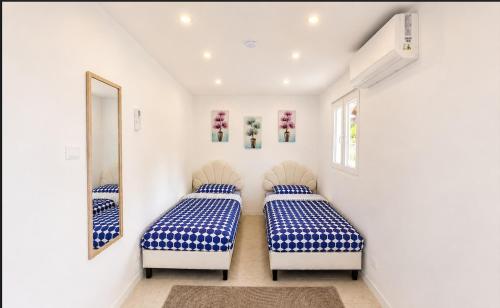 zwei Betten in einem Zimmer mit weißen Wänden in der Unterkunft PineHills in Torres Vedras